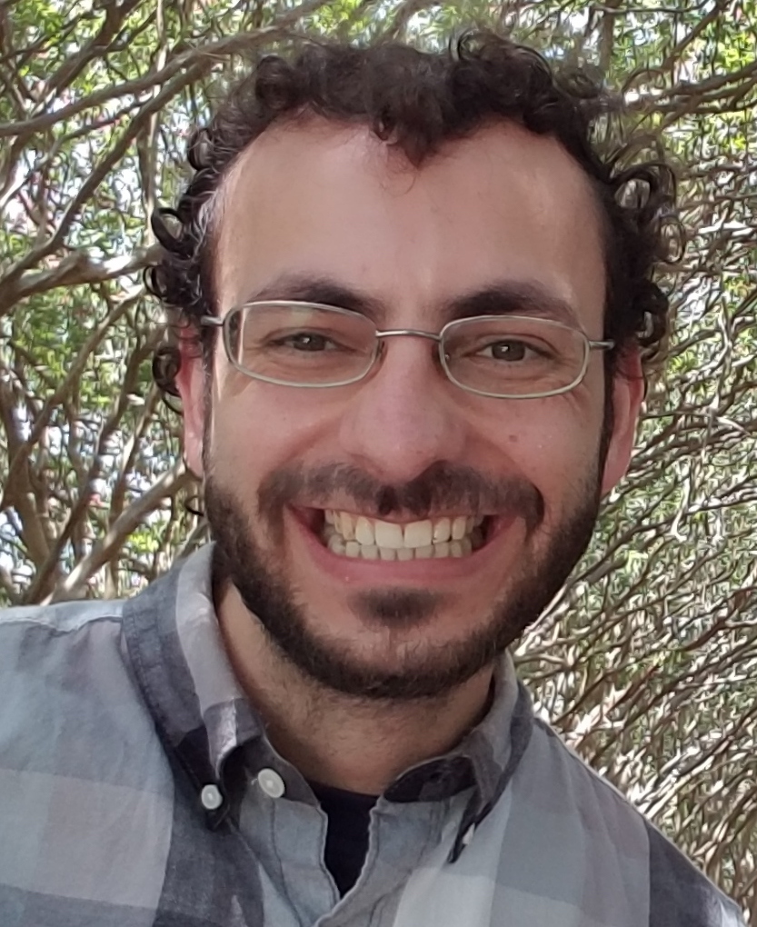 Website author smiling in front of trees.